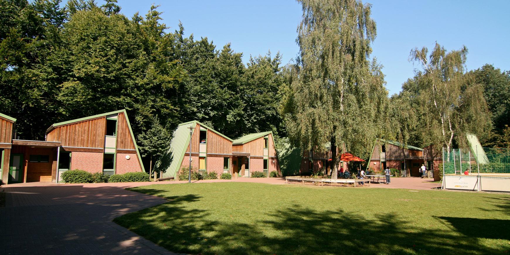 Outdoor-Gelände des Sport- und Erlebnisdorfes mit Gästehäusern im Hintergrund