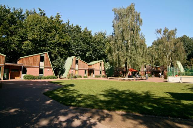 Outdoor-Gelände des Sport- und Erlebnisdorfes mit Gästehäusern im Hintergrund