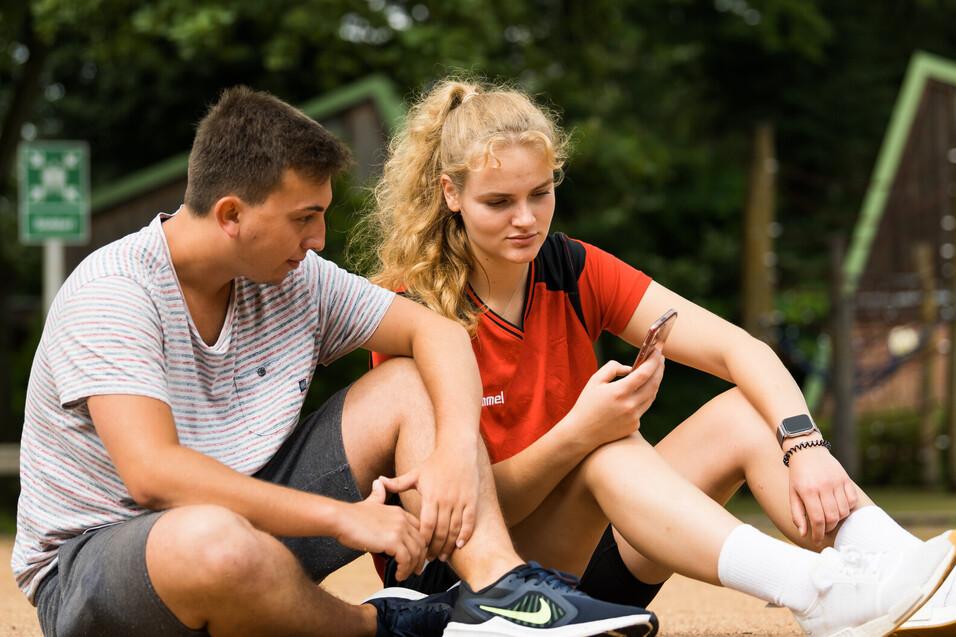 Kontakt Smartphone Zwei Jugendliche schauen auf ein Smartphone