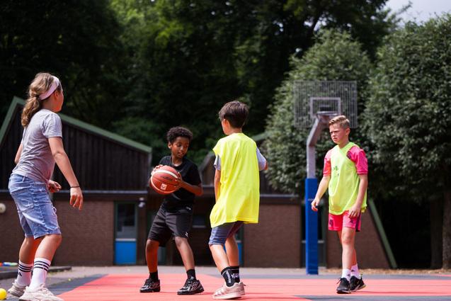 Jungen spielen outdoor Basketball